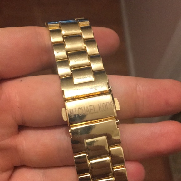 Hold Michael Kors watch.